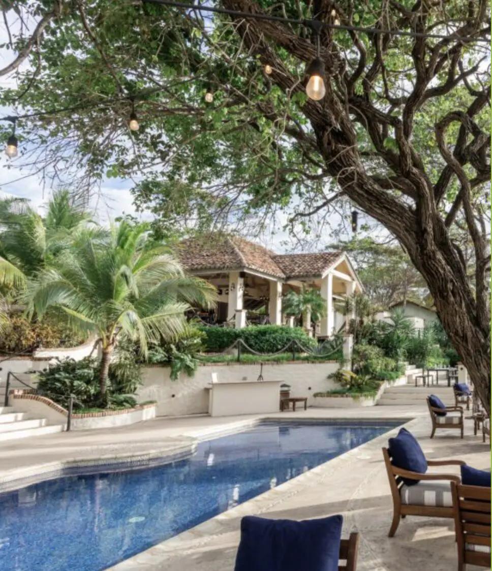 Restaurante La Boquita con piscina, árboles y luces colgantes